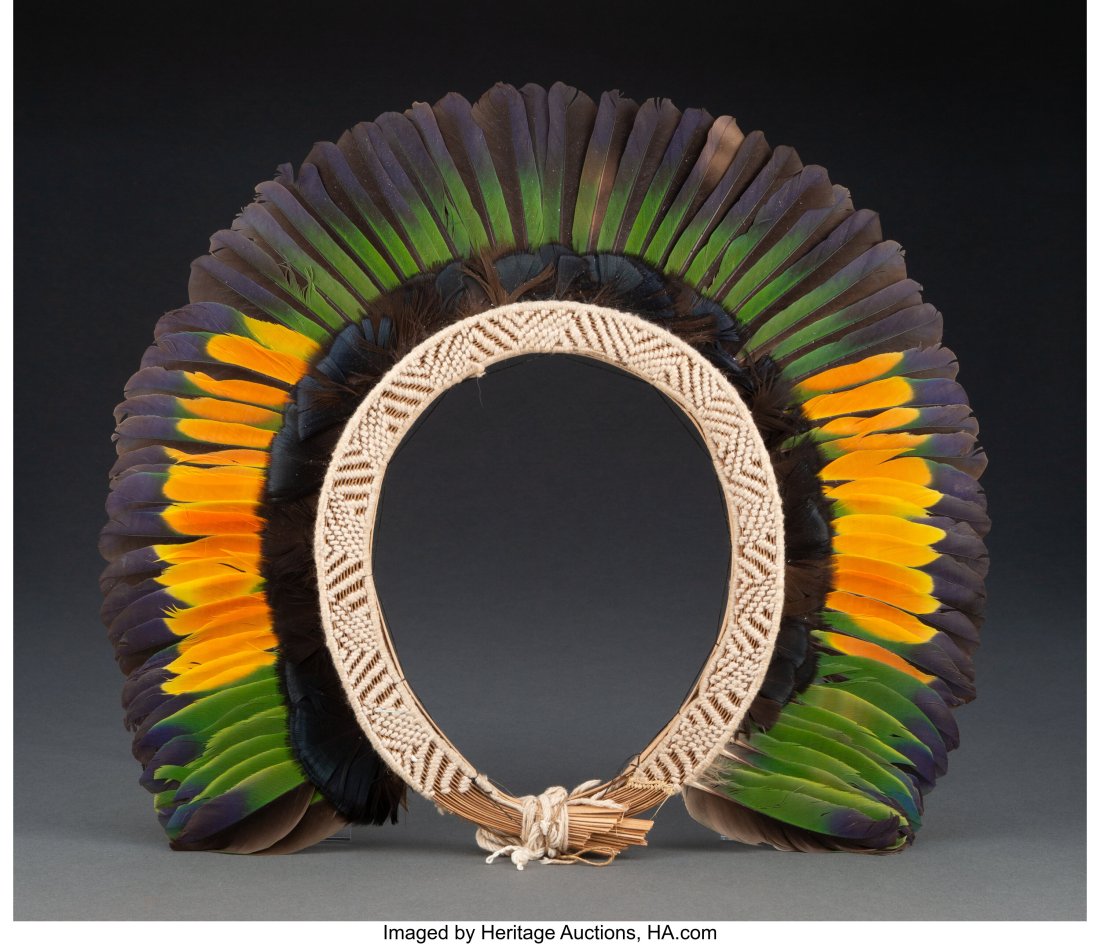 A Kayapo Headdress Xingu River area, Mato Gross: A Kayapo Headdress Xingu River area, Mato Grosso, Brazil, c. 20th century Domestic macaw and parrot feathers tied onto cotton, enclosed in a wicker frame. In exce