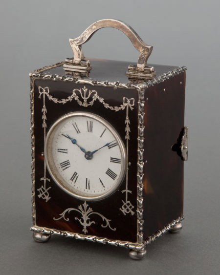 A CASED EDWARDIAN TORTOISESHELL AND SILVER CLOCK: A CASED EDWARDIAN TORTOISESHELL AND SILVER CLOCK Charles and Richard Comyns, London,