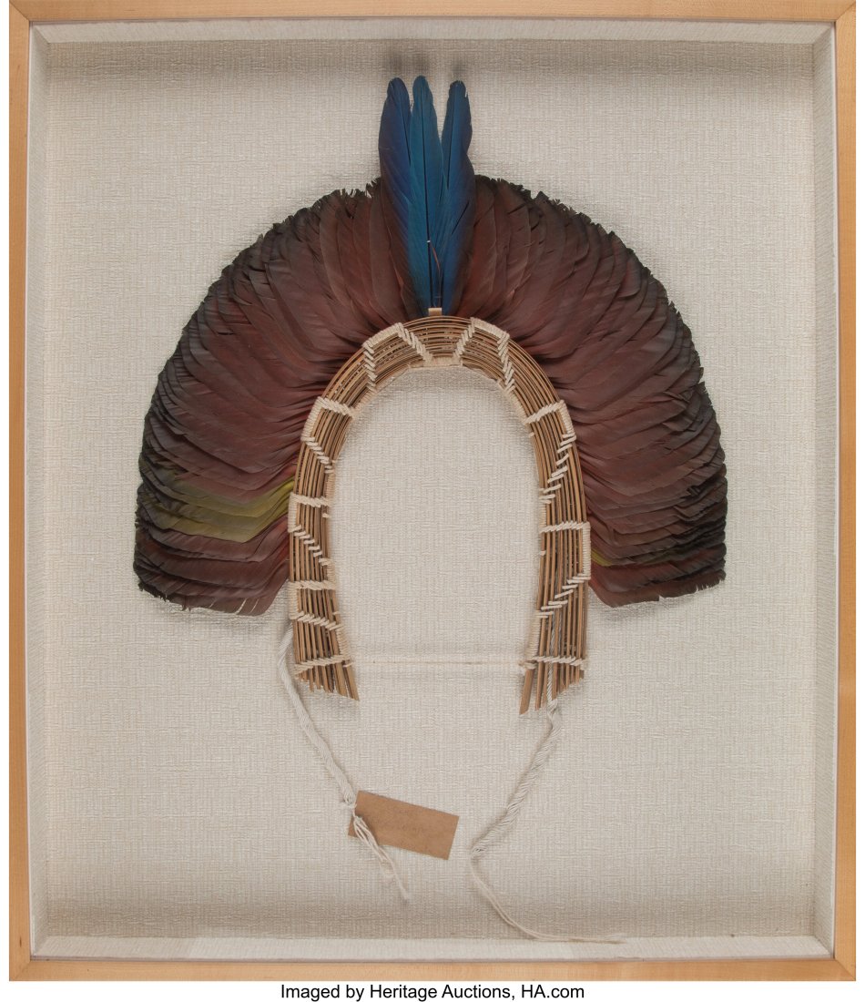 A Kayapo Feather Headdress Mato Grosso, Brazil: A Kayapo Feather Headdress Mato Grosso, Brazil A semicircular headdress of domestic bird feathers (parrot and macaw) strung on cotton which is tied in a pattern onto a bundle of thin r