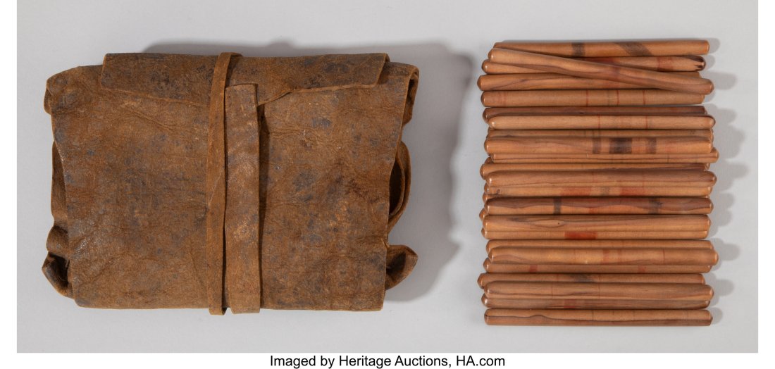 A Set of 29 Northwest Coast Gaming Sticks with H: A Set of 29 Northwest Coast Gaming Sticks with Hide Pouch c. 1875 wood, pigments; hide, sinew; accompanied by a "Memo, from the desk of Robert H. Kuck" inscri