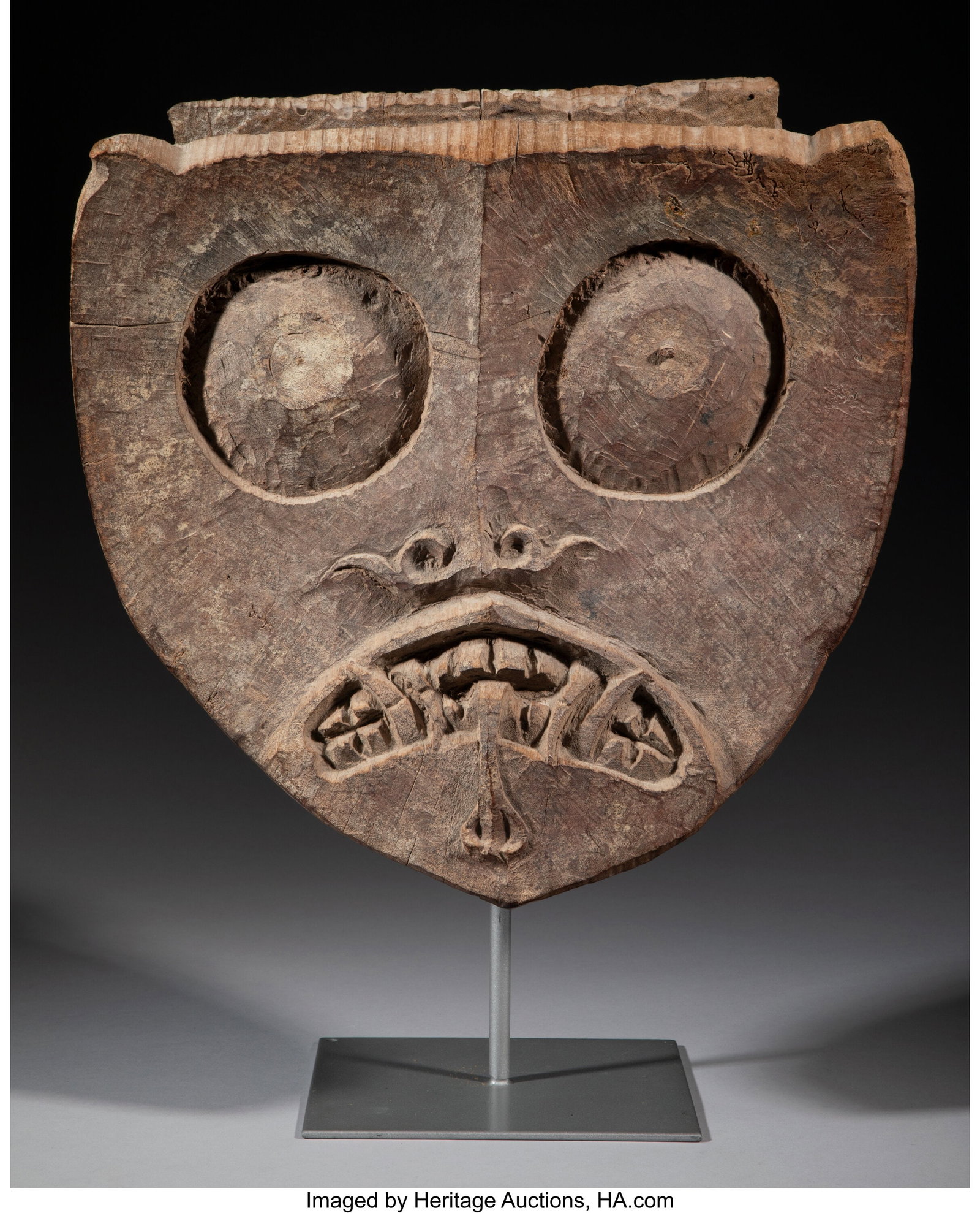 A Kayan Dayak Coffin End Kalimantan/Borneo, Ind: A Kayan Dayak Coffin End Kalimantan/Borneo, Indonesia, c. 18th to 19th century Hardwood carved in form of a guardian figure with the classic triangular Kayan Dayak spirit head f