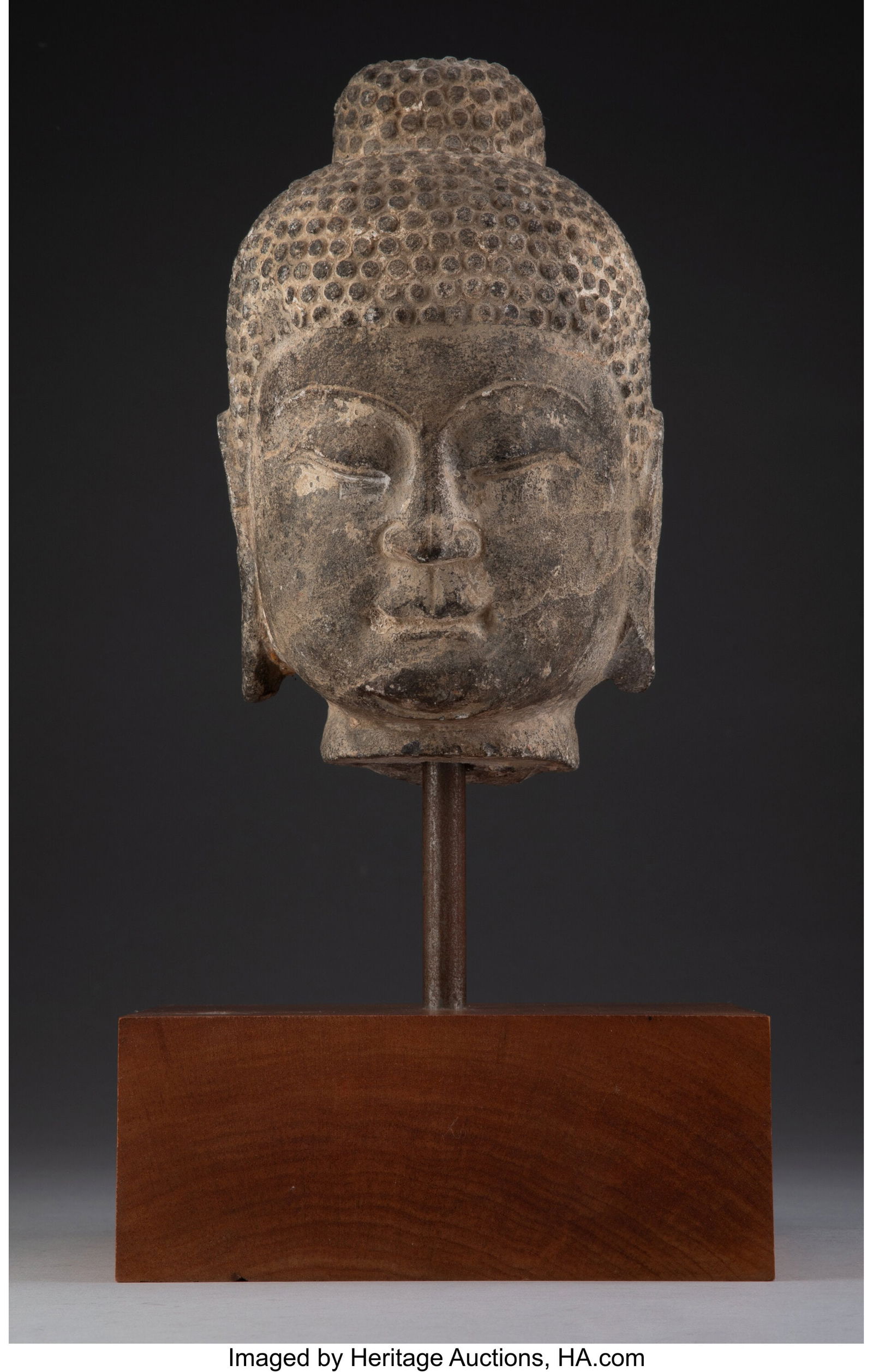 A Carved Stone Head of a Figure Accompanied by S (1 of 2)