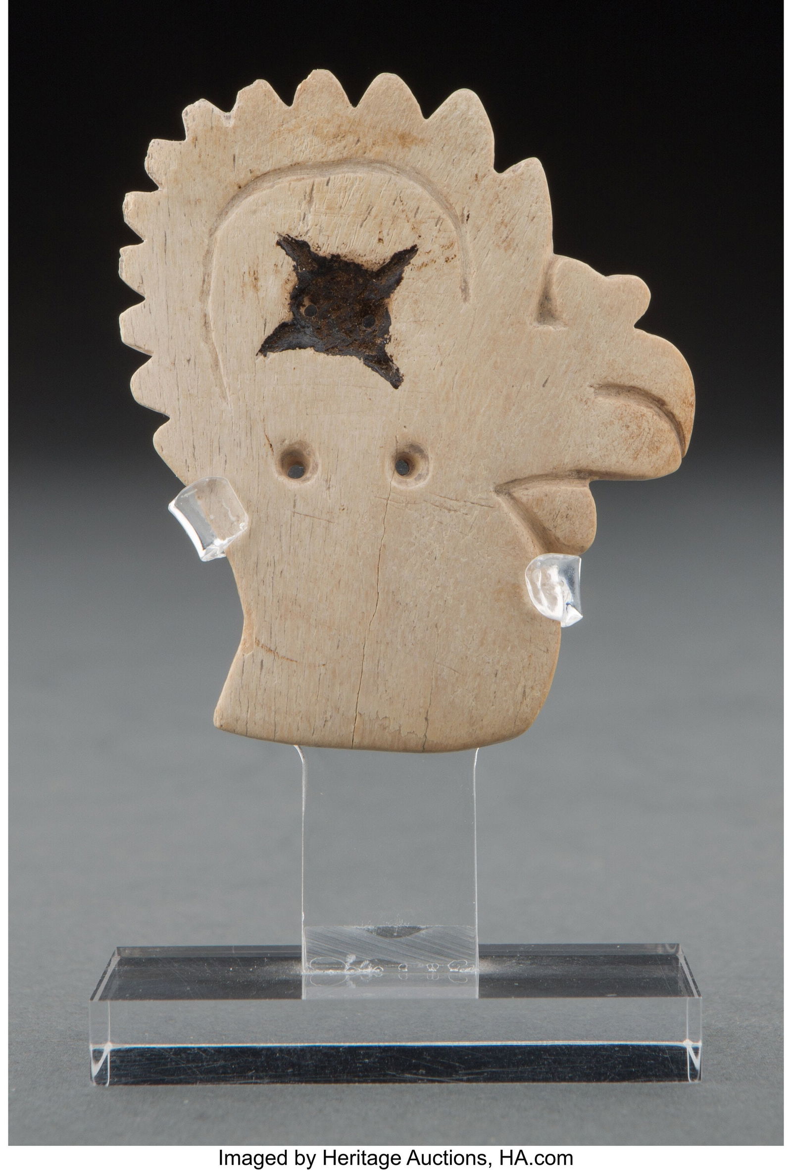 A Nazca Carved Bird Head Peru, 100 - 600 AD, Ea: A Nazca Carved Bird Head Peru, 100 - 600 AD, Early Intermediate Period This carved bone depicts a stylized bird head in profile. Dark and hardened resin is embedded in the circular