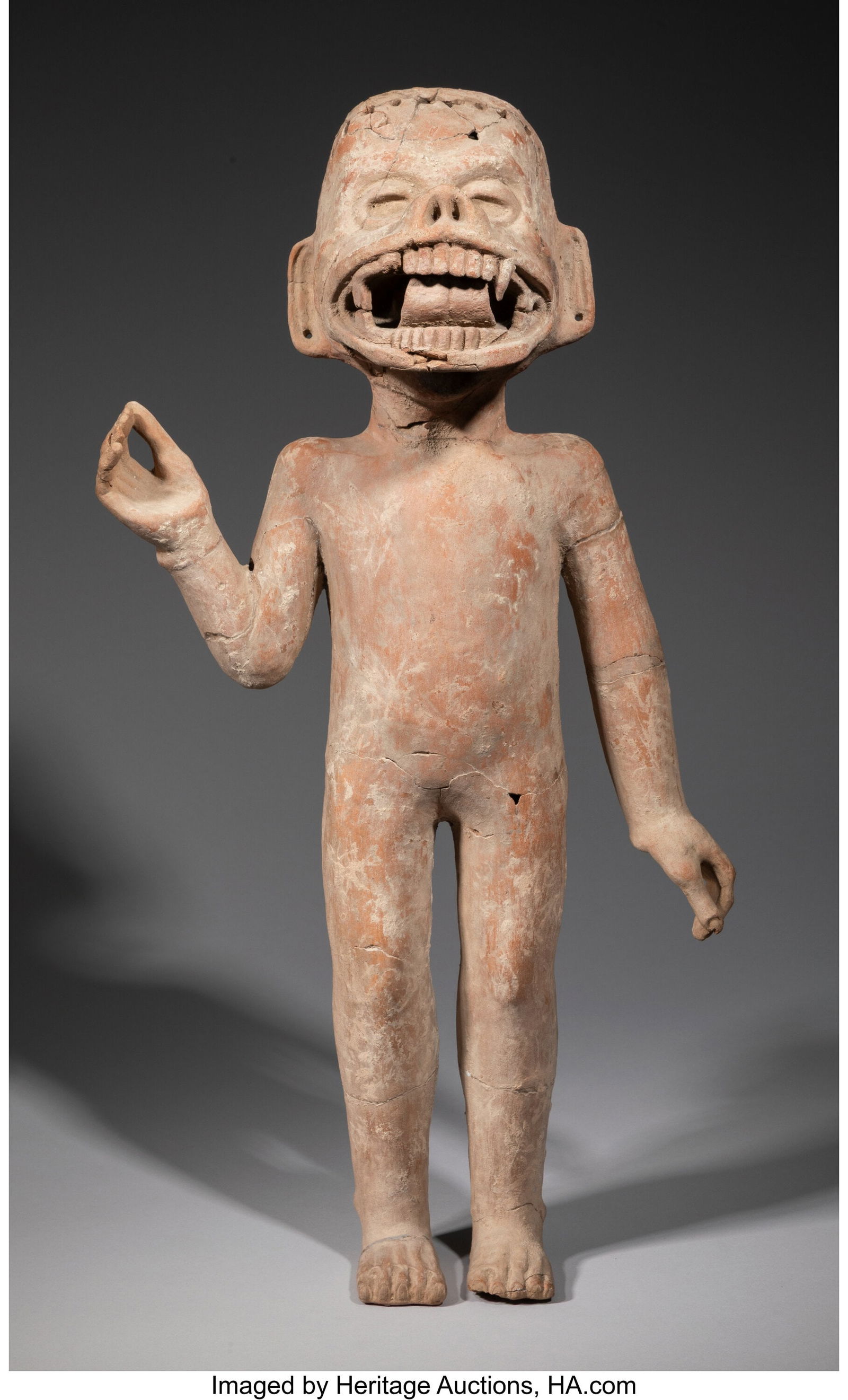 A Large Veracruz Figure Wearing a Mask c. 600 -: A Large Veracruz Figure Wearing a Mask c. 600 - 900 AD The youthful body standing erect with proper right hand raised; covering the mouth and nose is a projecting mask of a fierce beast's