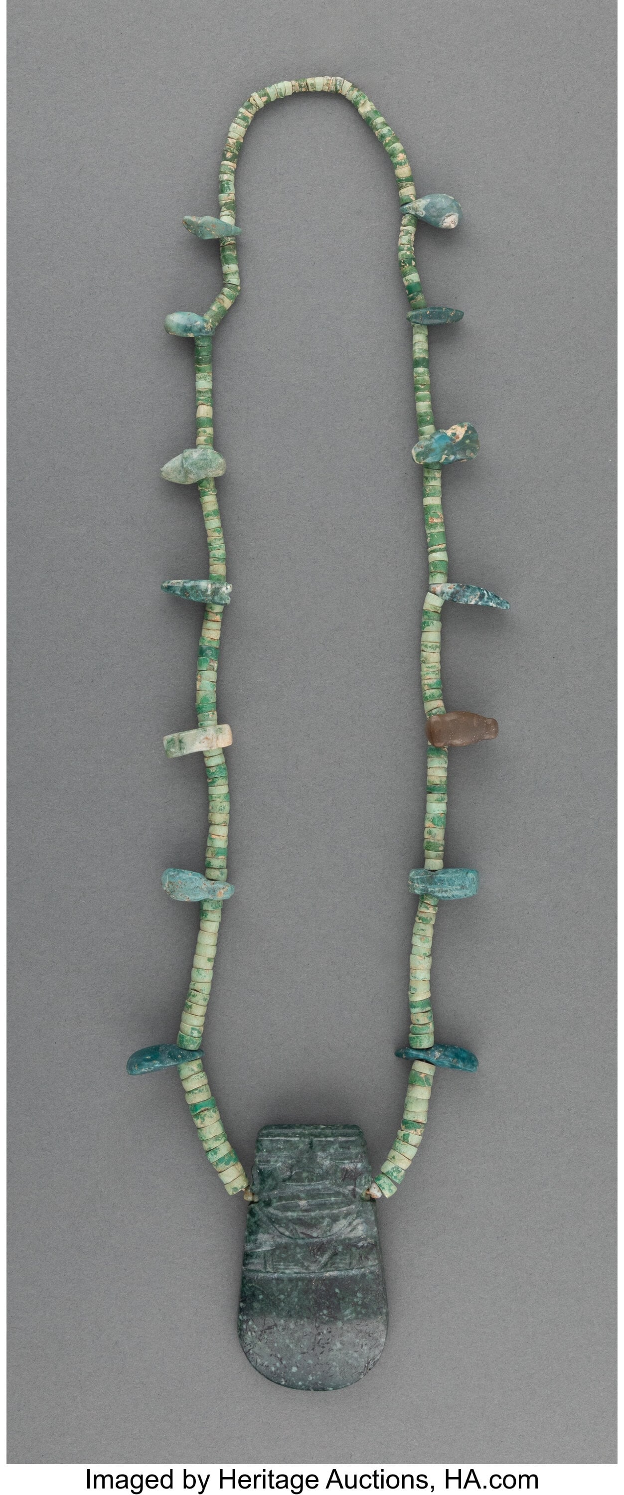 A Necklace with Jade Axe God Celt Pendant and Ja: A Necklace with Jade Axe God Celt Pendant and Jade Beads Costa Rica, c. 100-700 AD The pendant speckled dark green jade pendant deeply grooved on one side to depict the Axe God with a wid