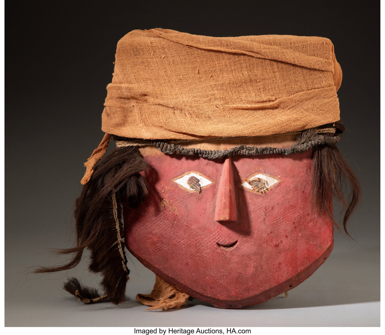 A Chancay Mask Peru, c. 1000 – 1460 AD Wood,: A Chancay Mask Peru, c. 1000 – 1460 AD Wood, the front painted with red pigment, remains of white pigments and a tar-like substance with remains of gauze textile at the
