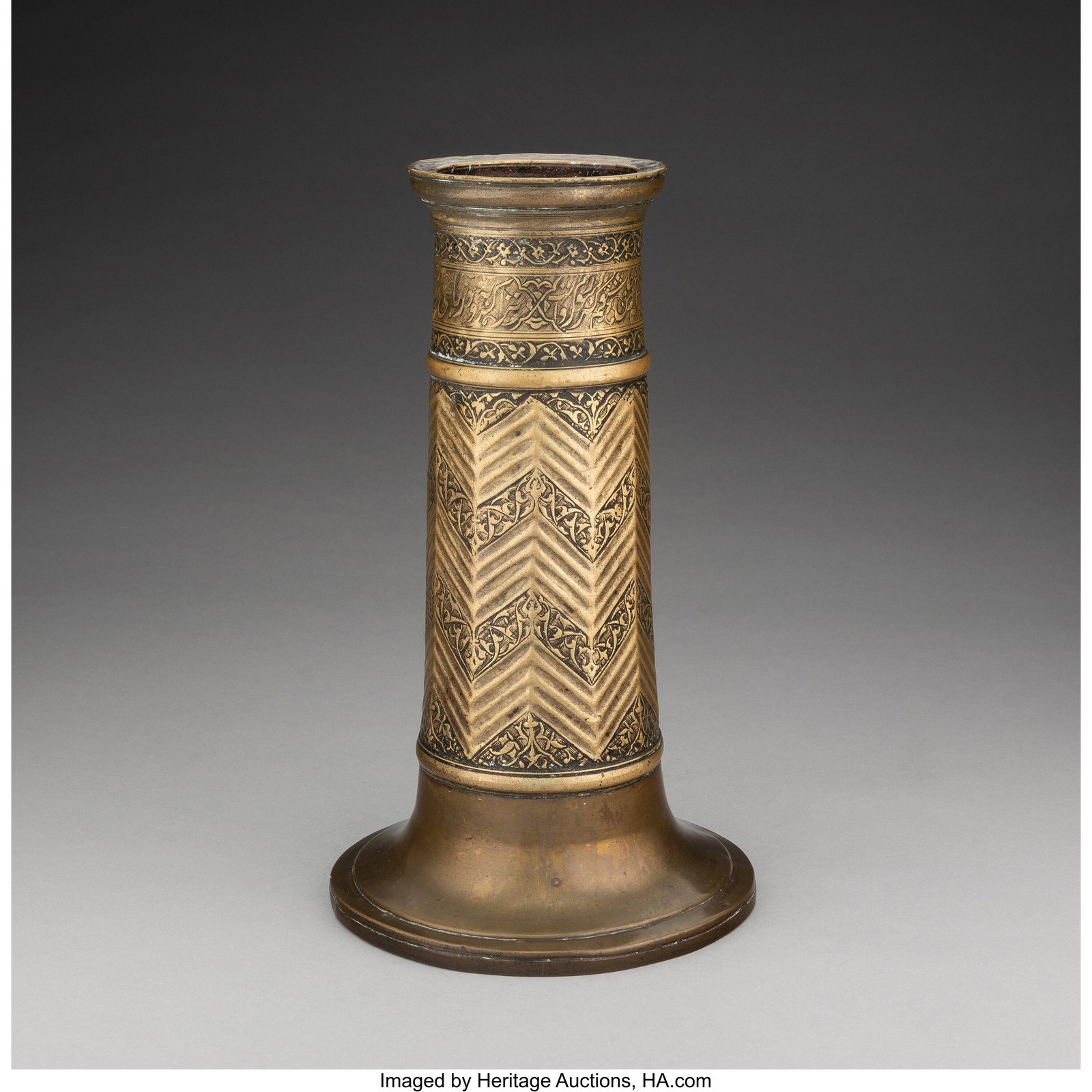 A Safavid Brass Torch Stand, 17th century 11-1/2: A Safavid Brass Torch Stand, 17th century 11-1/2 x 6-5/8 inches (29.2 x 16.8 cm) HID03101062020 © 2025 Heritage Auctions | All Rights Reserved www.HA.com/TexasAuctioneerLicenseNotice