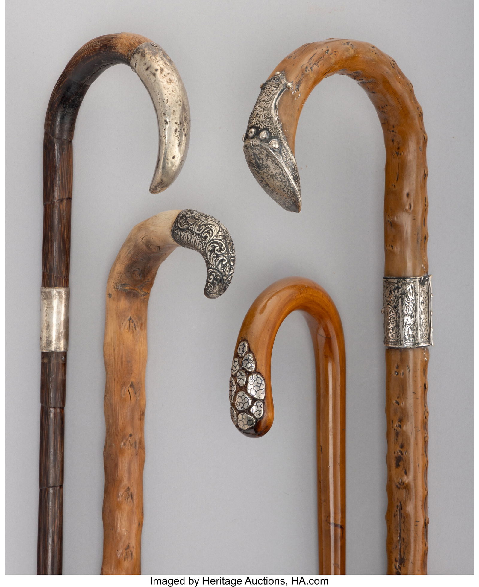 Four Silver-Mounted, Carved Wood, and Bamboo Can: Four Silver-Mounted, Carved Wood, and Bamboo Canes, circa 1899 and later Marks to one: 925/1000, FINE 36-1/2 x 4-1/2 inches (92.7 x 11.4 cm