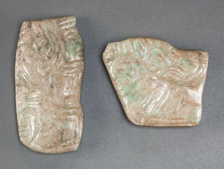TWO MAYA GRAY-GREEN PENDANTS c. 600 - 900 AD: TWO MAYA GRAY-GREEN PENDANTSc. 600 - 900 AD The first, drilled horizontally, shows a crouching lord in pr