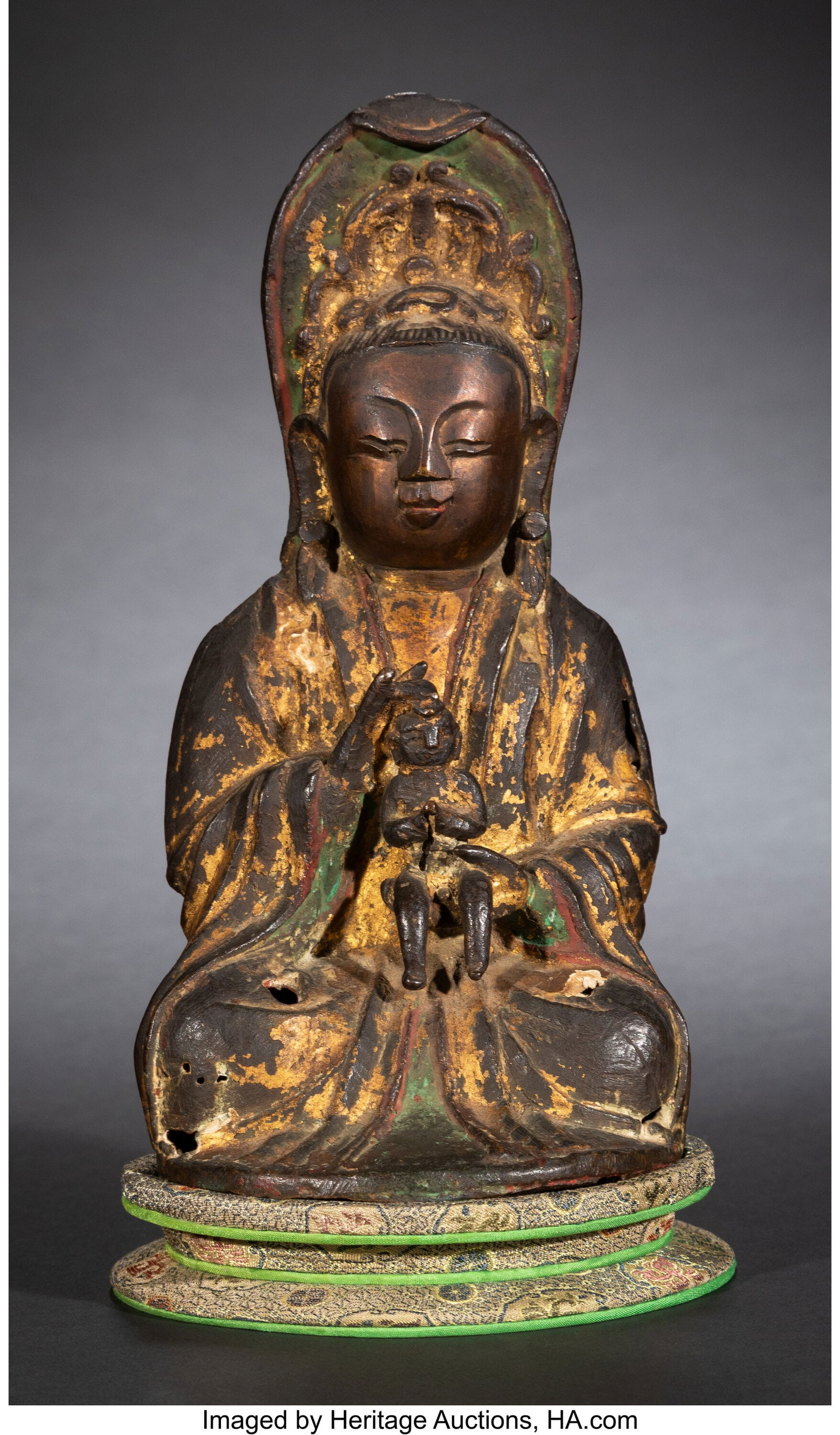 A Chinese Gilt Bronze Guanyin Figure Carrying Ch: A Chinese Gilt Bronze Guanyin Figure Carrying Child, Ming dynasty 7-3/8 x 4-1/4 x 4 inches (18.7 x 10.8 x 10.2 cm) (work) Property from the