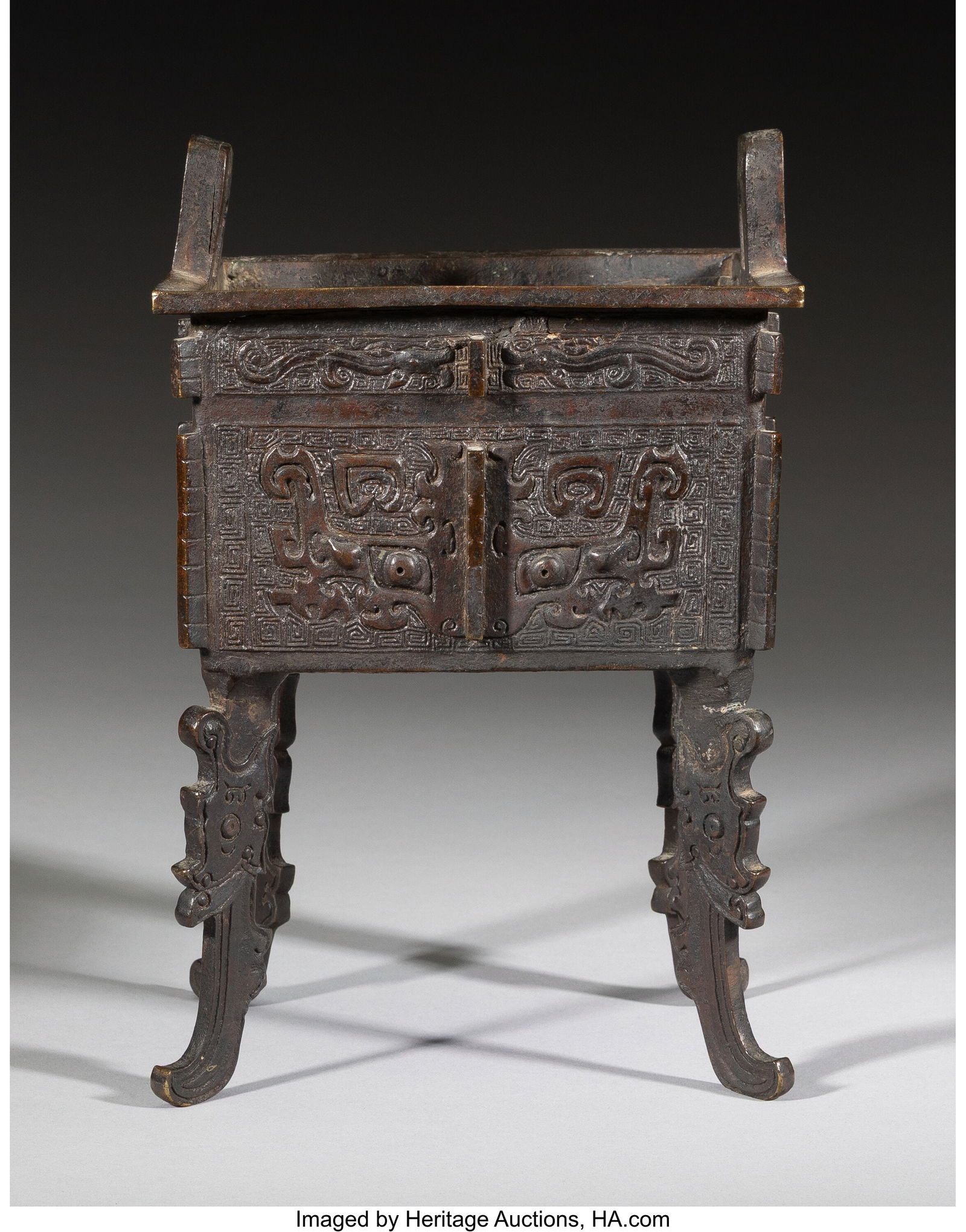 A Chinese Bronze Footed Ding Inscribed to interi: A Chinese Bronze Footed Ding Inscribed to interior: (six-figure mark) 9-1/8 x 6-1/8 x 4-3/8 inches (23.2 x 15.6 x 11.1 cm) 