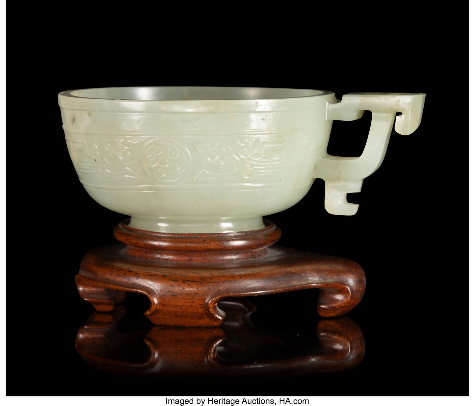 A Chinese White Jade Handled Cup, early Qing dyn: A Chinese White Jade Handled Cup, early Qing dynasty 1-1/4 x 2-5/8 x 3-1/2 inches (3.2 x 6.7 x 8.9 cm) pale celadon jade handled cup of archaistic form