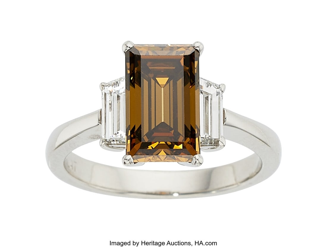 Fancy Dark Orangy Brown Diamond, Diamond, Plati: Fancy Dark Orangy Brown Diamond, Diamond, Platinum Ring Stones: Rectangular step-cut fancy dark orangy brown diamond weighing 2.70 carats; trapezoid-shaped near-colorless
