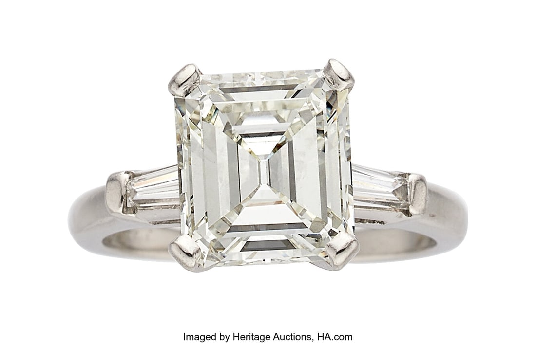 Diamond, Platinum Ring Stones: Emerald-cut diam: Diamond, Platinum Ring Stones: Emerald-cut diamond weighing 3.27 carats; baguette-cut diamonds weighing a total of approximately 0.15 carat Metal: Platinum Gross W