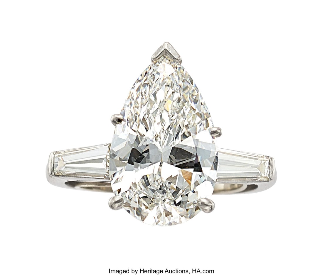 Diamond, Platinum Ring Stones: Pear-shaped diam: Diamond, Platinum Ring Stones: Pear-shaped diamond weighing 4.81 carats; tapered baguette-cut diamonds weighing a total of approximately 0.70 carat Metal: Platinum