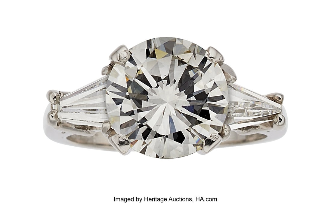 Diamond, Platinum Ring Stones: Round brilliant-: Diamond, Platinum Ring Stones: Round brilliant-cut diamond weighing 3.27 carats; baguette-cut diamonds weighing a total of approximately 1.00 carat Metal: Platinum