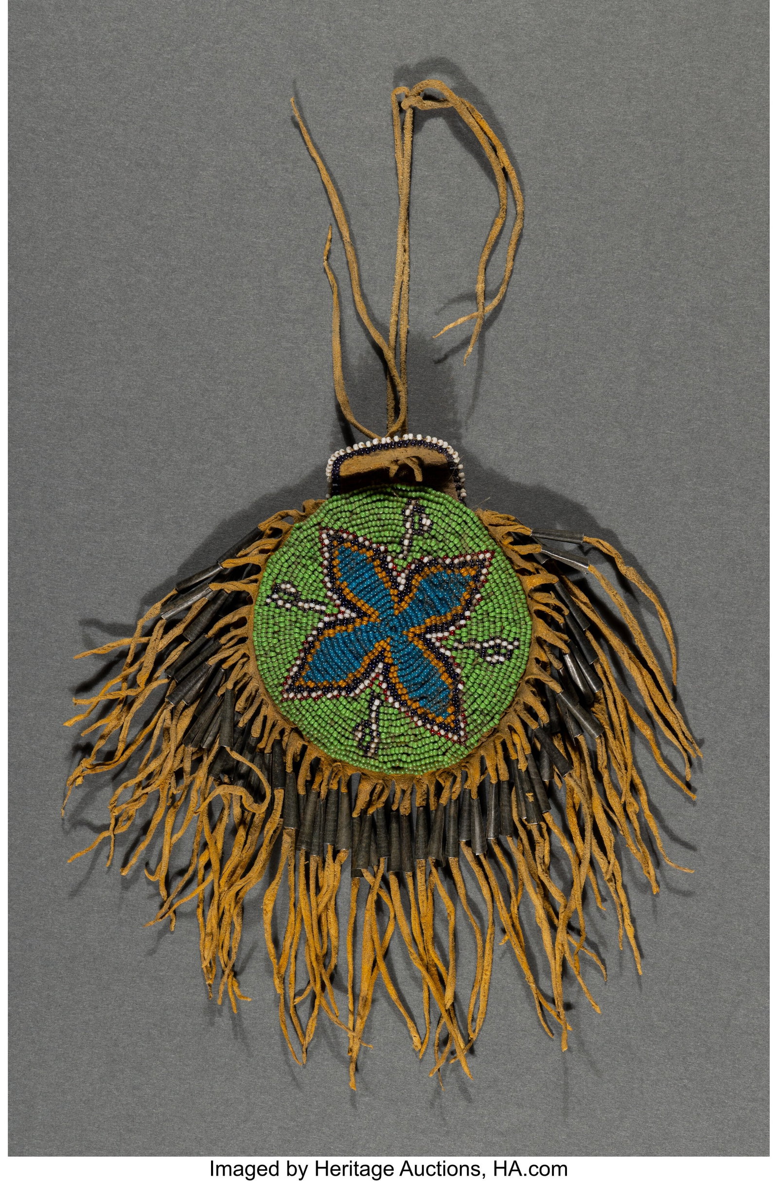 A Southern Plains Beaded Hide Peyote Pouch c. 1: A Southern Plains Beaded Hide Peyote Pouch c. 1900 hide, yellow ochre pigment, glass seed beads, metal cones, sinew Length: 8 inches overall HID03101062020 ©