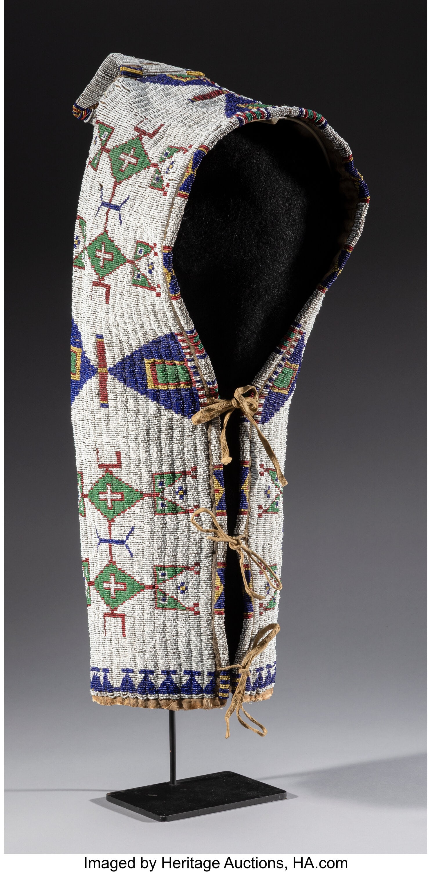 A Sioux Beaded Hide Baby Carrier c. 1890 hide,: A Sioux Beaded Hide Baby Carrier c. 1890 hide, glass seed beads, muslin, sinew Height: 24 inches, excluding top tab HID03101062020 © 2026 Heritage Auctions &v