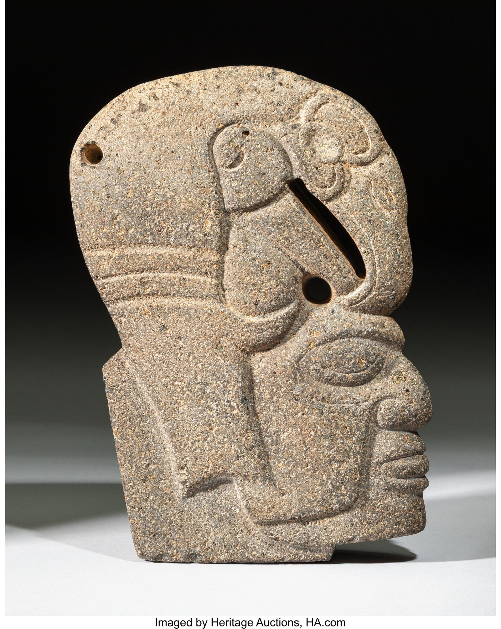 A Veracruz Stone Hacha Mexico, c. 600–900 AD : A Veracruz Stone Hacha Mexico, c. 600–900 AD Carved from gray stone, this hacha takes the form of a human head wearing a bird headdress. The face is composed with close