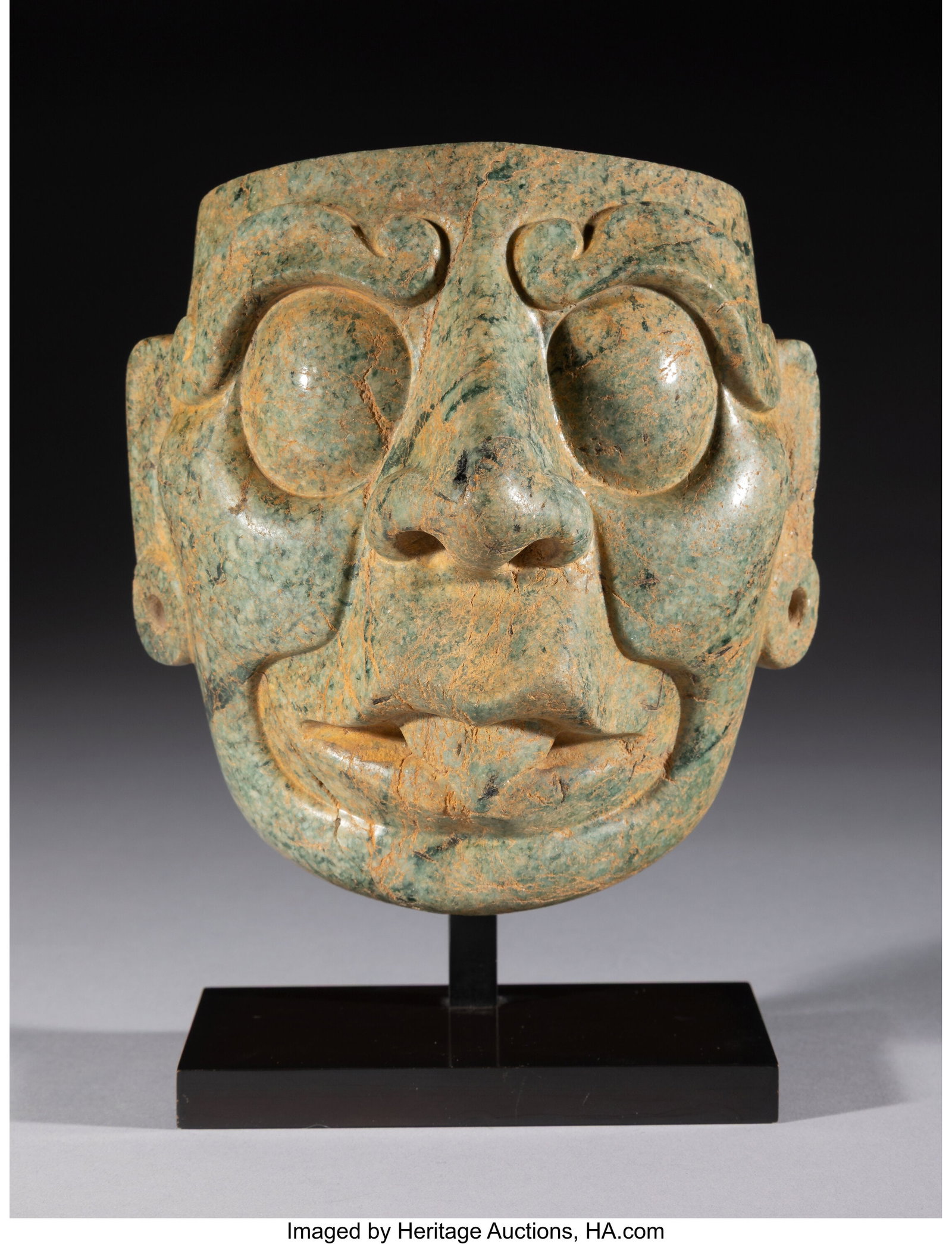 A Maya Stone Mask of the Sun God Mesoamerica, c: A Maya Stone Mask of the Sun God Mesoamerica, c. 600–800 AD Carved from polished mottled blue-green hardstone, this mask is identified as the sun god K'inich Ajaw by the promi