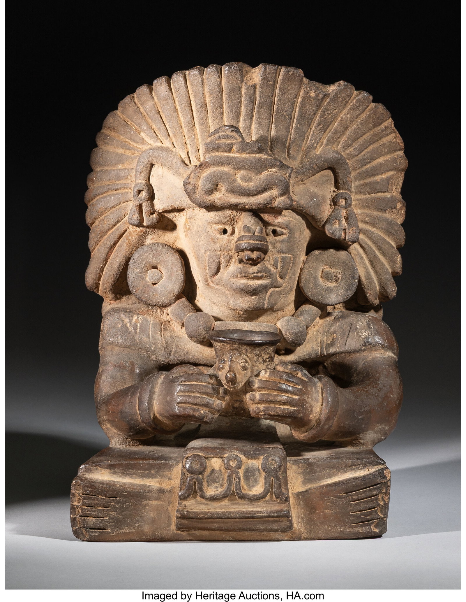 A Zapotec Urn Oaxaca, Mexico, c. 500–900 AD : A Zapotec Urn Oaxaca, Mexico, c. 500–900 AD Seated with the legs crossed, this figure is shown in an unusual act of presentation of a water jar. The hands hold fo