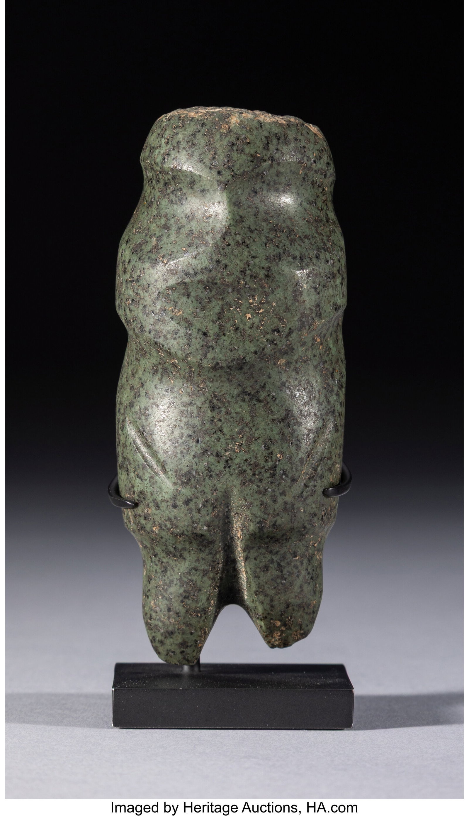 A Mezcala Figure, Type M-4: A Mezcala Figure, Type M-4 Mexico, c. 500 BC–500 AD A celt-form figure carved in a compact, abstract manner, with short legs and lightly incised grooves indicating the arms. Large eyes and a mouth