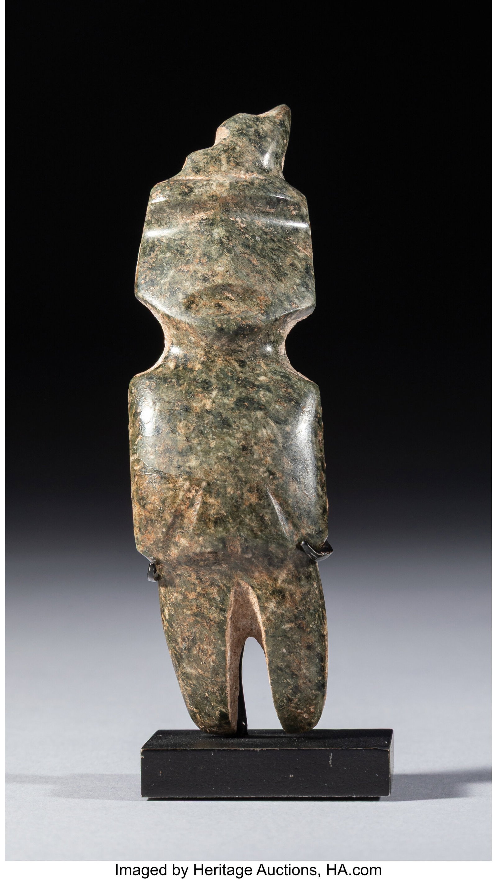 A Small Mezcala Figure Mexico, c. 300–100 BC: A Small Mezcala Figure Mexico, c. 300–100 BC Carved from dark green speckled stone, this thin M-10 type figure has a slightly arching form and a stepped headdress. The