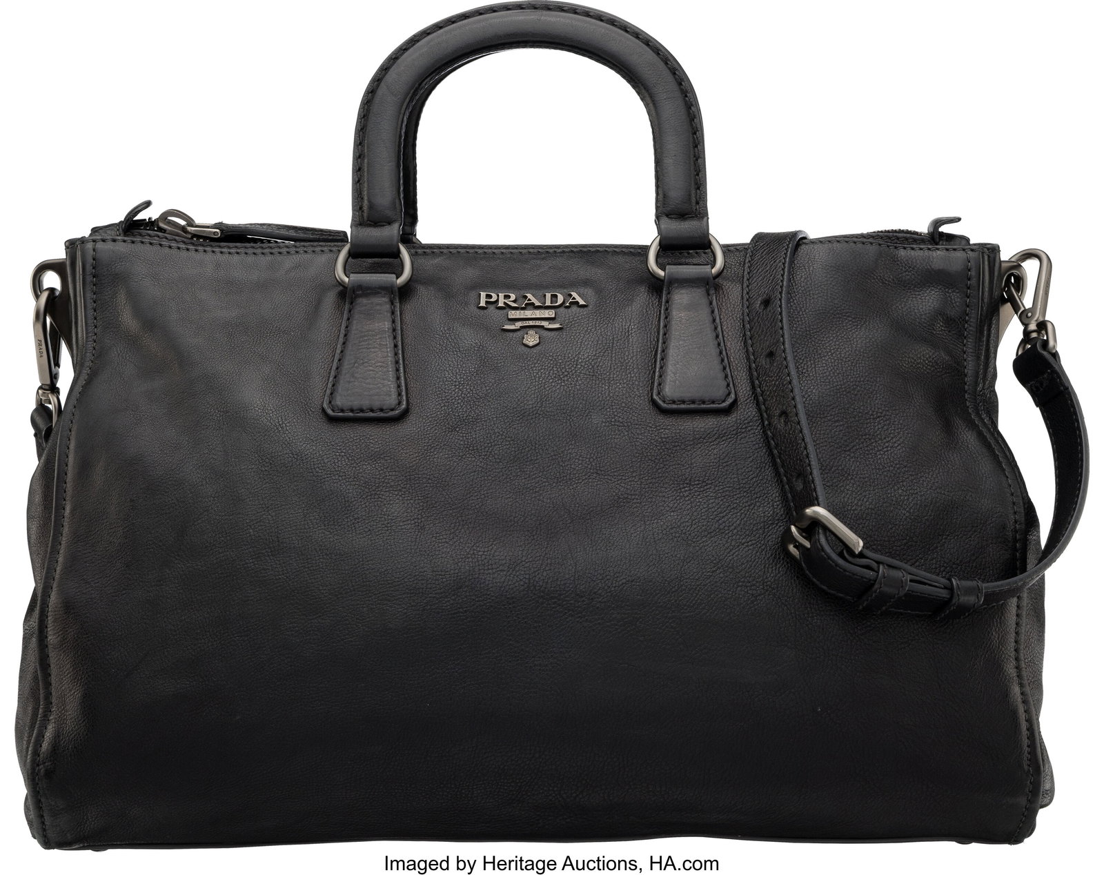 Prada Black Leather Tote Condition: 3 14.5" Widt: Prada Black Leather Tote Condition: 3 14.5" Width x 11" Height x 6" Depth This bag is done in Black Leather with Gunmetal Hardware, featuring a crossbody strap, two