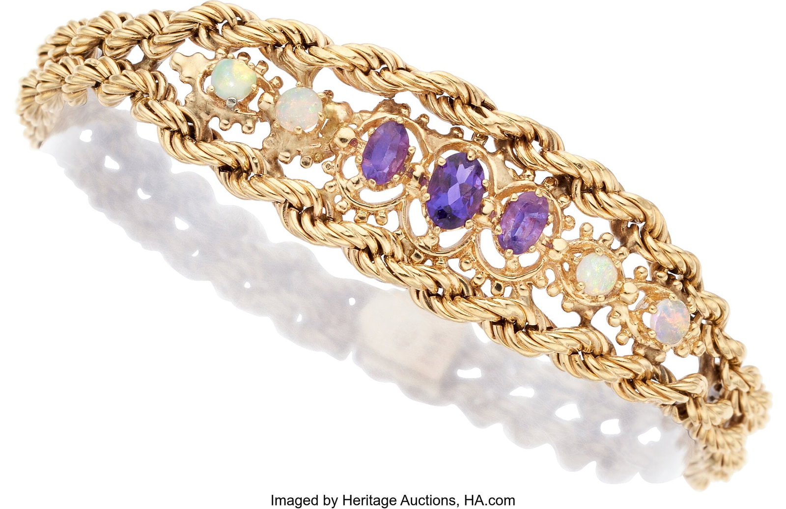 Amethyst, Opal, Gold Bracelet Stones: Oval-shap: Amethyst, Opal, Gold Bracelet Stones: Oval-shaped amethyst; opal cabochons Metal: 14k gold Gross Weight: 14.10 grams Dimensions: 7 inches x 5/8 inch