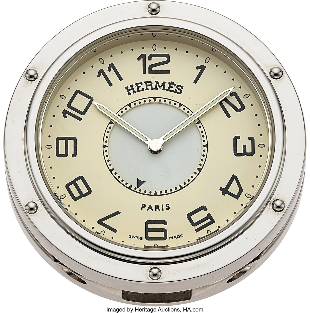 Hermès Clipper Stainless Steel Quartz Travel Cl: Hermès Clipper Stainless Steel Quartz Travel Clock Case: round polished silver-tone case with screw-accent bezel, hinged travel stand/base, and porthole-inspired Clipper d