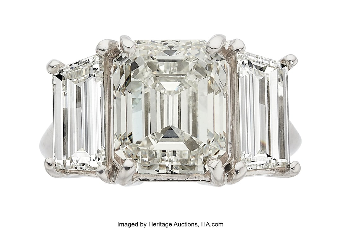 Diamond, Platinum Ring Stones: Emerald-cut diam: Diamond, Platinum Ring Stones: Emerald-cut diamond weighing 5.74 carats; trapezoid-shaped diamonds weighing a total of 2.69 carats Metal: Platinum Gross Weight&col