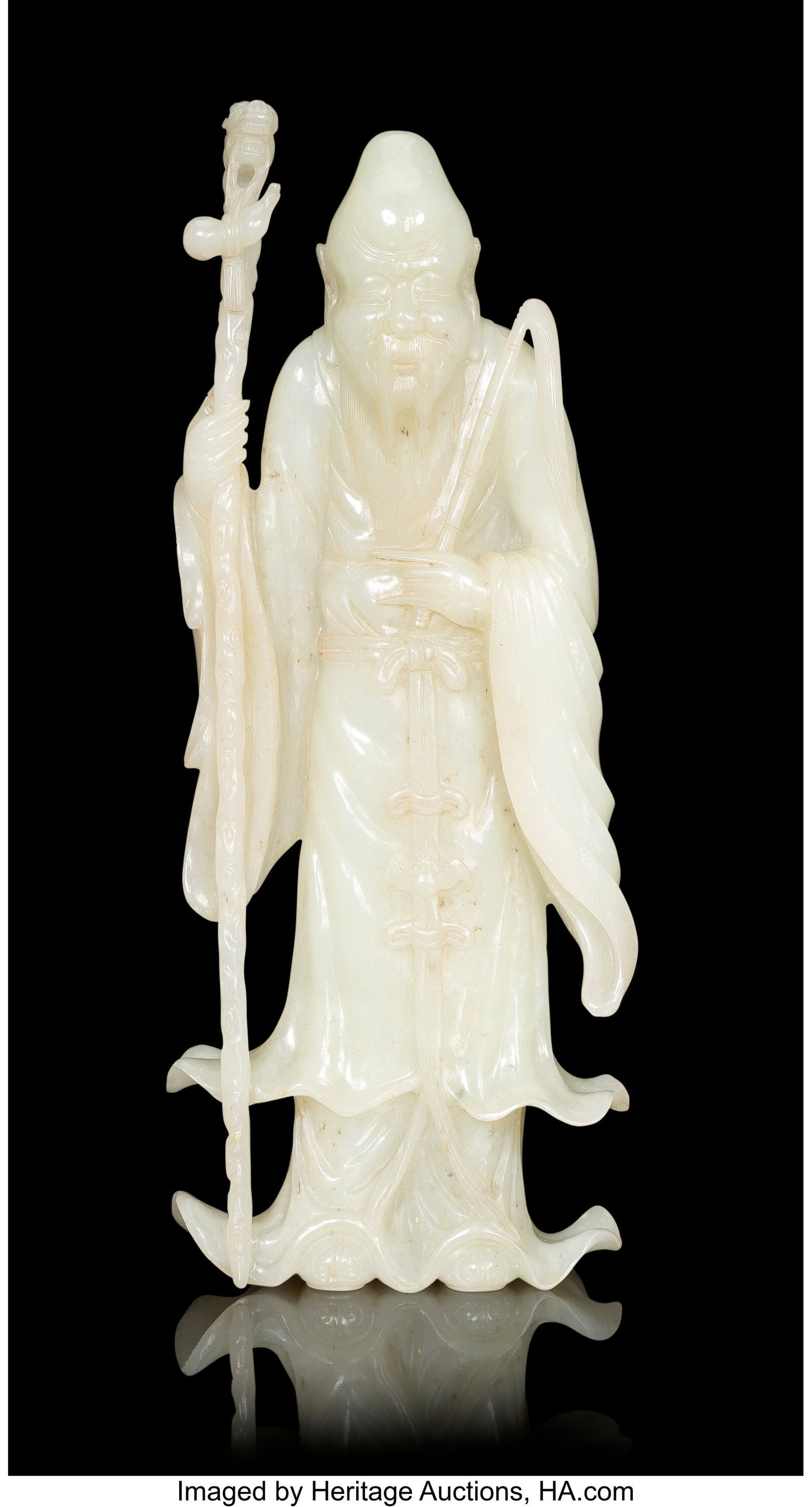 A Chinese Carved White Jade Figure of Shoulao wi: A Chinese Carved White Jade Figure of Shoulao with Staff, early 19th century 9-3/4 x 4 x 1-1/2 inches (24.8 x 10.2 x 3.8 cm) finely carved standing holding
