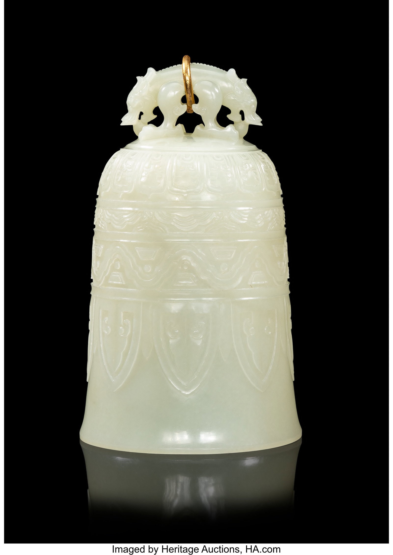A Chinese Carved Pale Celadon Jade Bell, Qing dy: A Chinese Carved Pale Celadon Jade Bell, Qing dynasty 6-7/8 x 3-1/2 inches (17.5 x 8.9 cm) the bell topped by a double-headed beast finial with a gold ring,