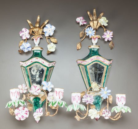 A PAIR OF CONTINENTAL PORCELAIN TWO-LIGHT GILT A: A PAIR OF CONTINENTAL PORCELAIN TWO-LIGHT GILT AND ENAMEL MIRRORED WALL SCONCES Late