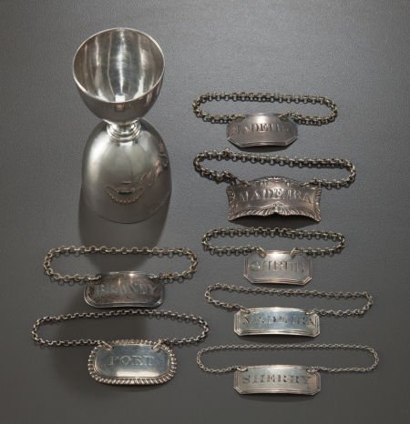 A ROBERT PRINGLE & SONS LATE VICTORIAN SILVER JI: A ROBERT PRINGLE & SONS LATE VICTORIAN SILVER JIGGER WITH SEVEN SILVER BOTTLE TAGS BY VARIOUS MAKERS</
