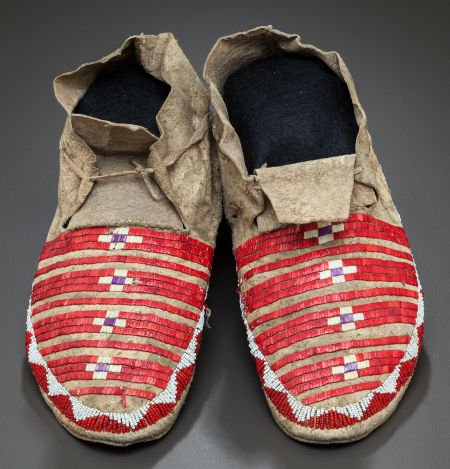 A PAIR OF SIOUX QUILLED AND BEADED HIDE MOCCASIN: A PAIR OF SIOUX QUILLED AND BEADED HIDE MOCCASINSc. 1890 with natural, purple and red-d