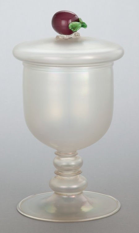 AN IRIDESCENT GLASS COVERED URN WITH FRUIT FINIA: AN IRIDESCENT GLASS COVERED URN WITH FRUIT FINIAL 20th century 11-1/2 inches high (29.2
