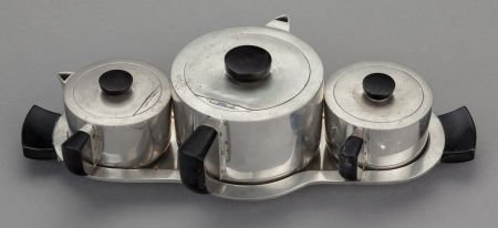 A FOUR PIECE AMERICAN PEWTER AND BAKELITE TEA SE: A FOUR PIECE AMERICAN PEWTER AND BAKELITE TEA SERVICE, Designed by Jean Theobald and Styl