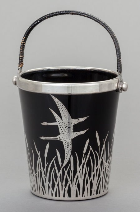 AN AMERICAN BLACK GLASS, RATTAN AND SILVER OVERL: AN AMERICAN BLACK GLASS, RATTAN AND SILVER OVERLAY ICE BUCKET, attributed to Rockwell Sil