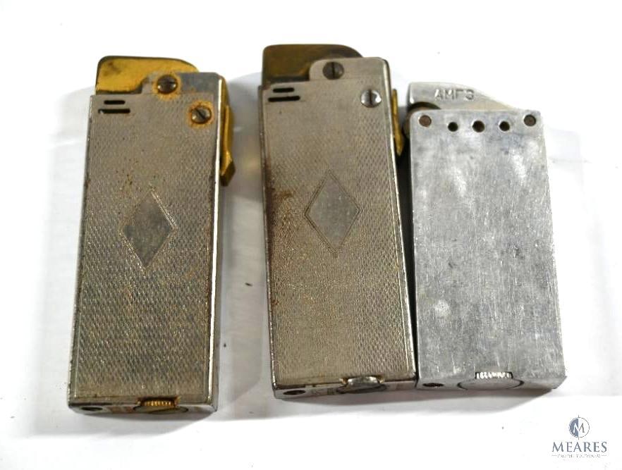 Three Vintage Lighters: One vintage aluminum block lighter with AMR3 on the side. Two vintage Thorens lighters made in Switzerland.