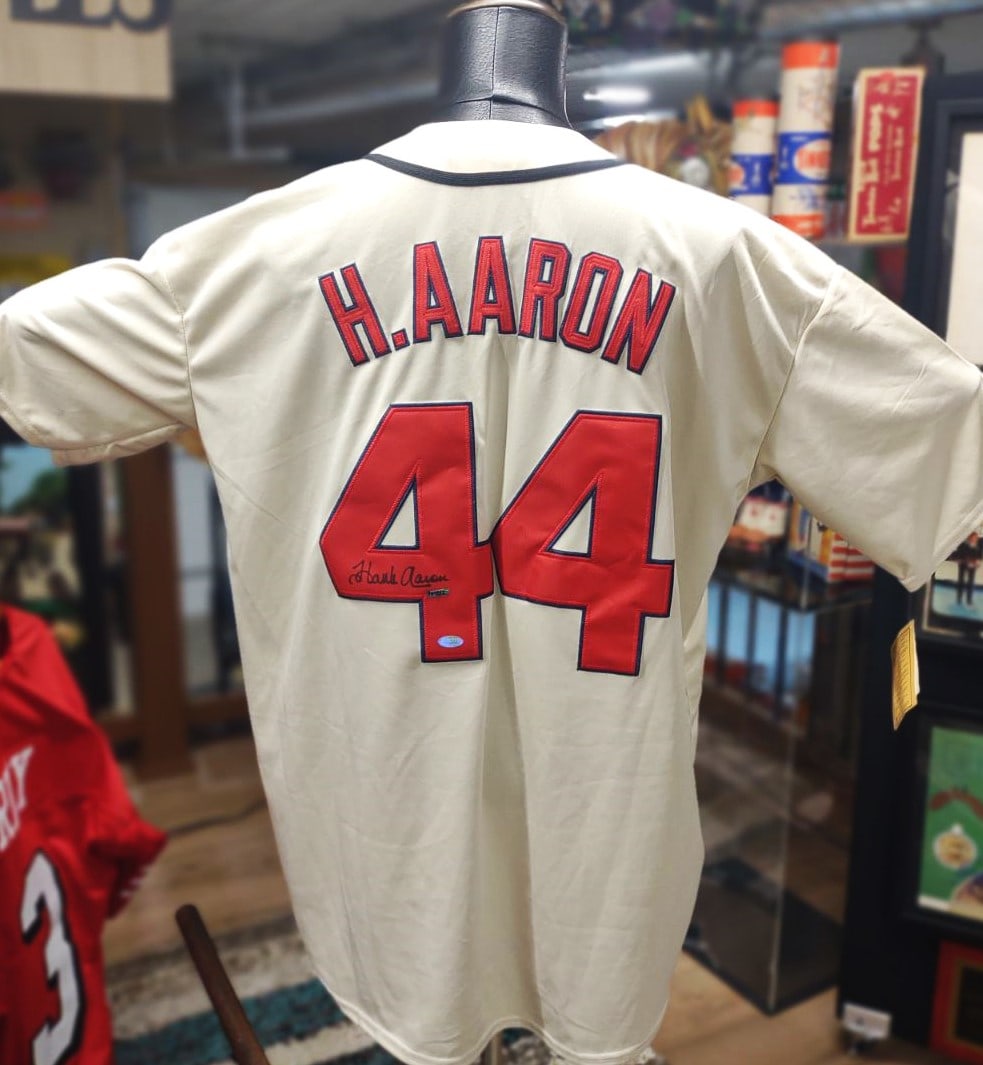 HANK AARON JERSEY FROM THE "HOME RUN KING" SIGNED AUTHENTICATED: HANK AARON SIGNED FORENSICALLY AUTHENTICATED BRAVES JERSEY The Jersey features the name "H. AARON" on the back above the number "44." This is a clear reference to Henry "Hank" Aaron, a Hall of Fame