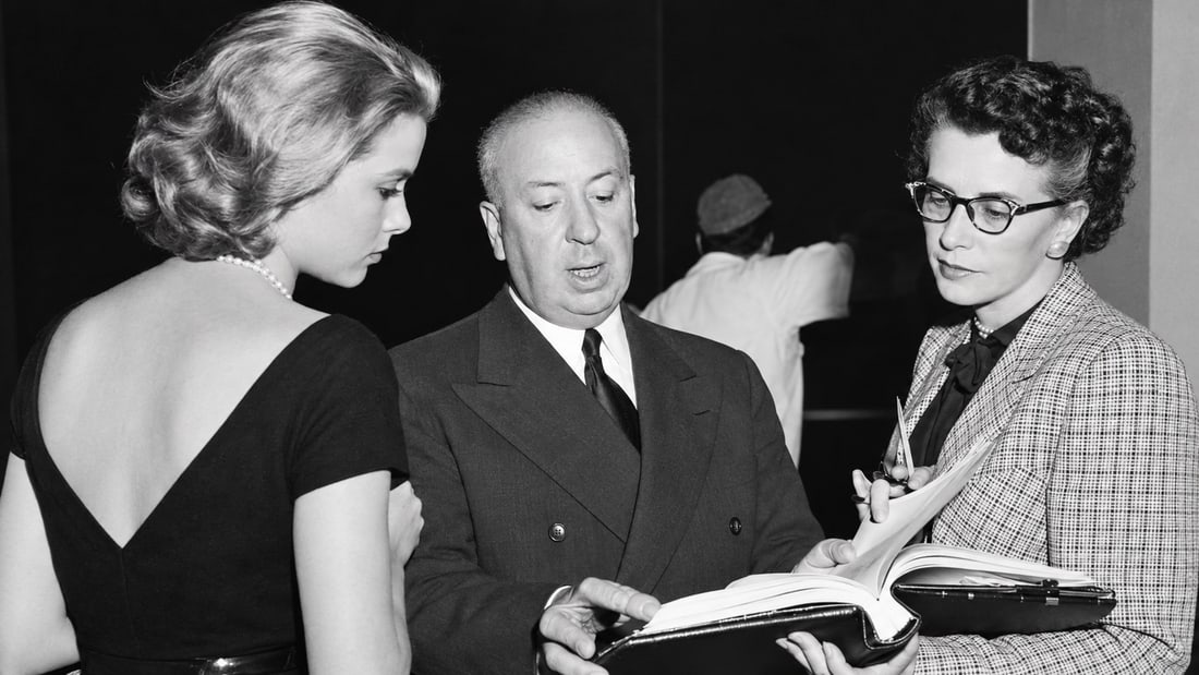 ALFRED HITCHCOCK & GRACE KELLY HAND SIGNED VINTAGE CUT AUTHENTICATED AND PHOTO: ALFRED HITCHCOCK WITH GRACE KELLY — BEHIND-THE-SCENES HOLLYWOOD PHOTOGRAPH Striking black-and-white Hollywood photograph featuring legendary filmmaker Alfred Hitchcock with Grace Kelly during a behi