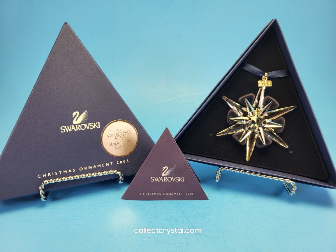 Swarovski 2005 Annual Star / Snowflake Ornament 680502: The retired limited edition Swarovski ornament was issued by D. Swarovski. This piece has 12 points 6 long, 6 short and has a metal tag with 2005 etched on it. Boxed in inner fitted and outer triangul