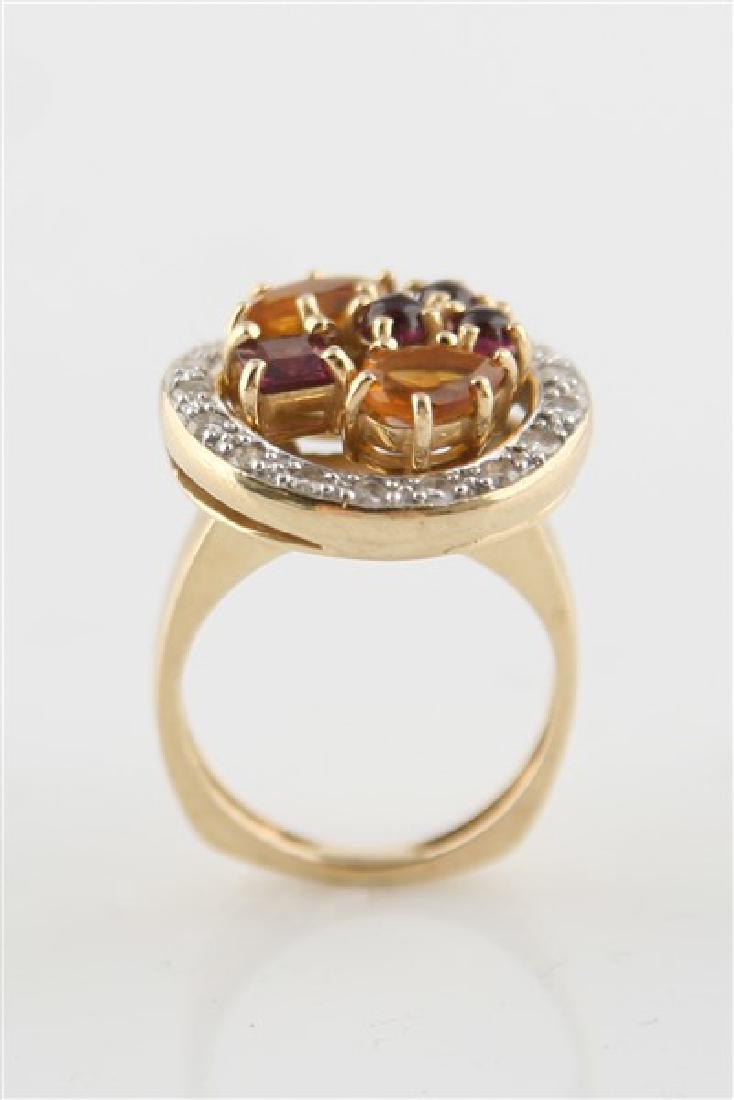 14k Gold Ring with Citrine and Garnet: 14k gold ring with marquise, pear, square, and round gemstones of citrine and garnet in the center of a round base with clear stones. Center stones are prong-set. Engraved "14k" on upper shank and hal