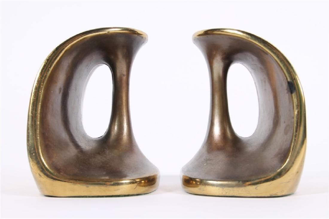 Ben Seibel for Jenfred Ware, Pair of Book Ends: Ben Seibel (American, 1918-1985). Metal. c. 1950's. Manufactured by Jenfred Ware. Height: 5", Length: 5 1/4", Depth: 3 1/2". Pair of brass tone handle bookends feature organic forms with felt to under