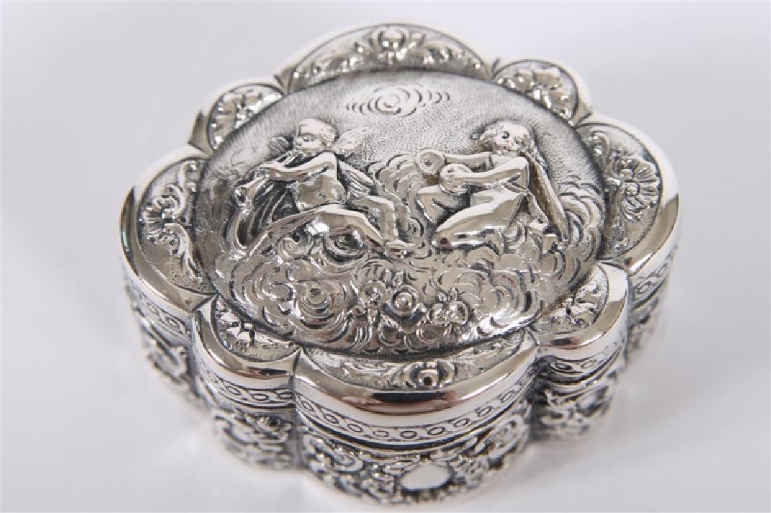 Friedrich Reusswig, Sterling Silver Trinket Box: Friedrich Reusswig (Germany, 1903-1926). Length: 2 7/8", Depth: 2 3/8", Height: 1 1/2". Weight: 2.725 ozt. Hinged box features an oval form with repousse ornamentation including floral and scroll moti