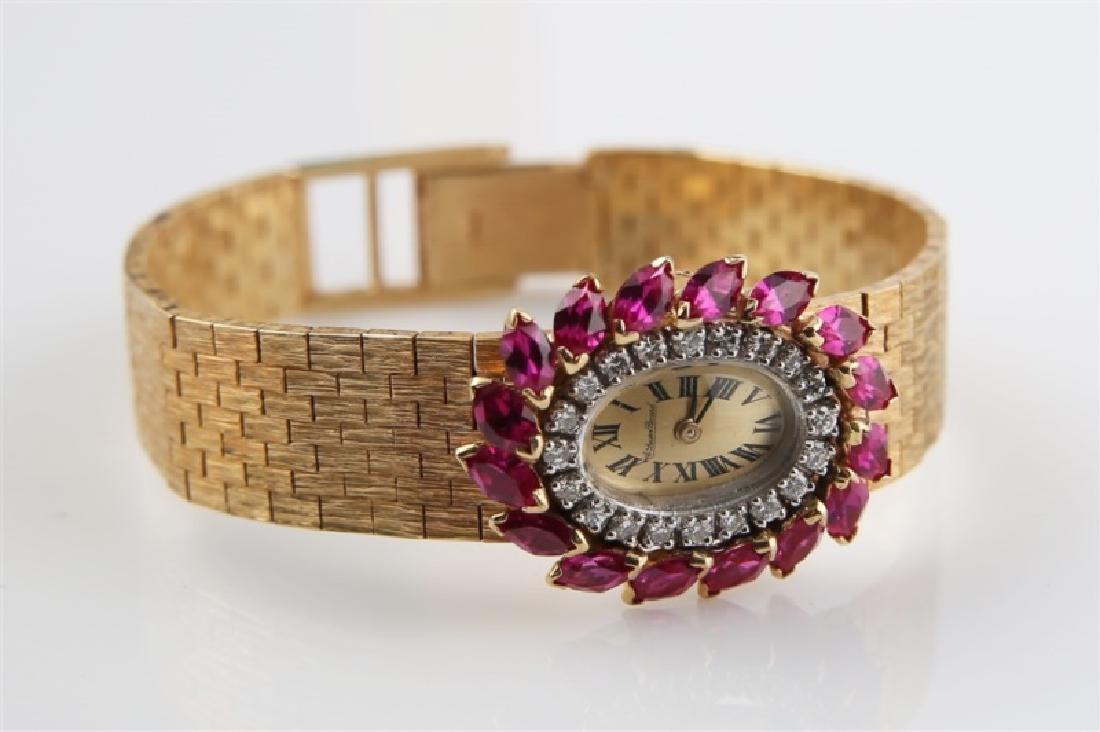 Lucien Piccard (Swiss), 14kt Gold Wrist Watch: Lucien Piccard (Swiss, est. 1923). 14kt yellow gold, rubies, moissanite. Length: 6 1/2". Box Height: 1 1/2", Length: 9", Depth: 4". Weight: 34.2 grams. 14kt yellow gold, ruby, and moissanite lady's wr