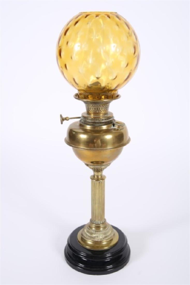 Young's Central Draught Victorian Oil Lamp: Young's Paraffin Light & Mineral Oil Company (English, est. 1866). Brass. Model: Court 20'". Height: 25 1/2", Dia.: 8" approx. Victorian brass oil lamp with amber glass bulb on round black metal base.
