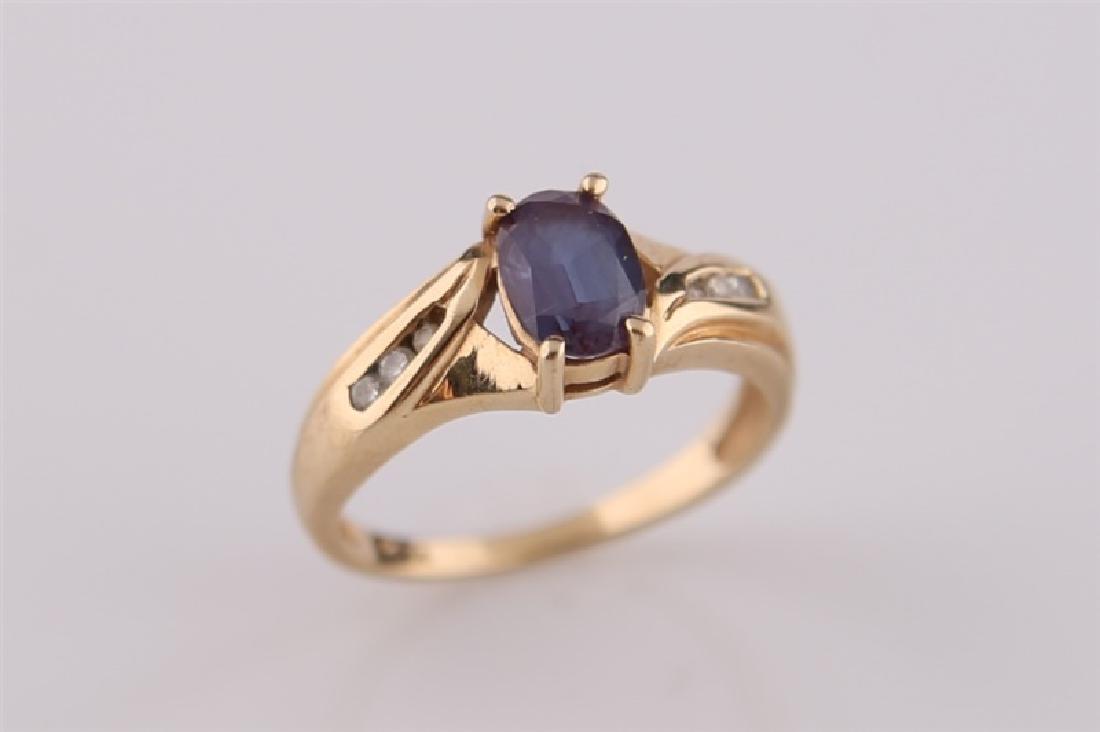 10kt Yellow Gold and Mystic Topaz Ring: 10kt yellow gold ring with dark stone likely mystic topaz. Stone flanked by three moissanite pieces on each side. Interior of band marked "10K". Size: 5 1/2. Weight: 2.6 g.