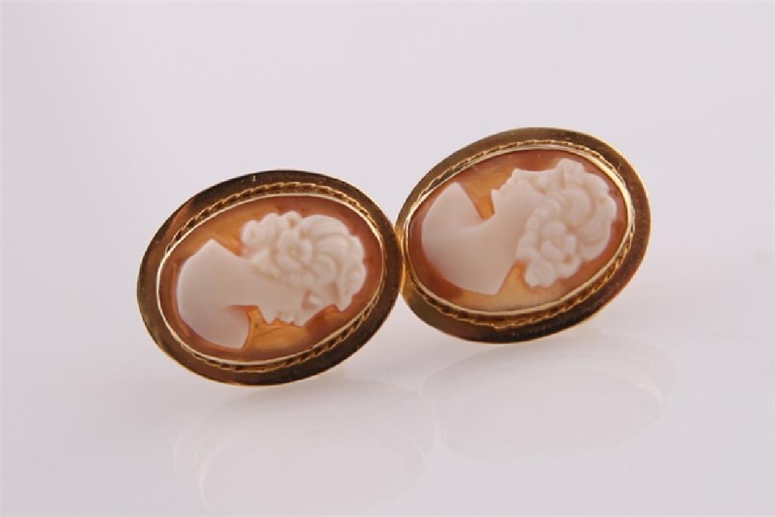 Pair of 14kt Yellow Gold Cameo Earrings: Pair of 14kt yellow gold cameo earrings. Post backs. Back of earrings marked "580" and "14k Italy". White cameo bust of a woman with pink ground. Length: 5/8". Weight: 2.5 g.